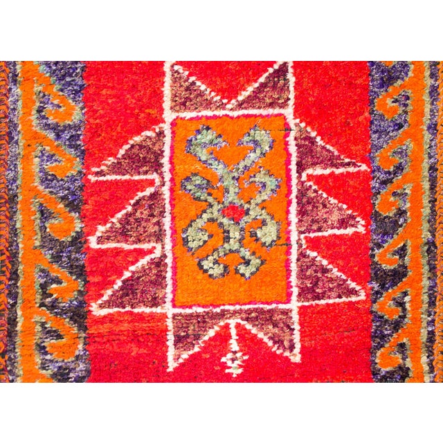 A bold and brilliant mid-20th century Turkish rug with four large stylized floral medallions woven in vibrant pinks,...