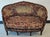 A French Louis XV style Settee features walnut frame with carved foliate, floral and scroll decoration; upholstered in...