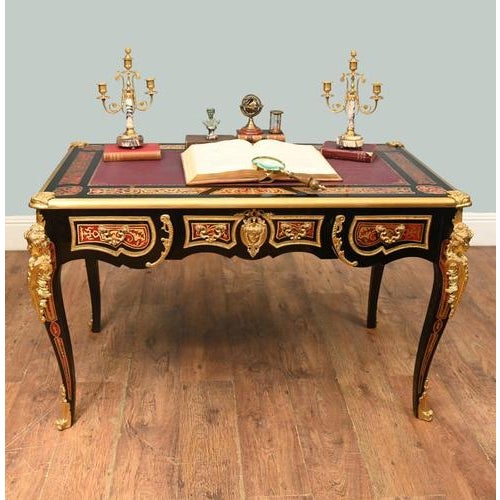 A magnificent french boulle style writing desk, richly decorated with ormolu mounts and vibrant red and black panels in...