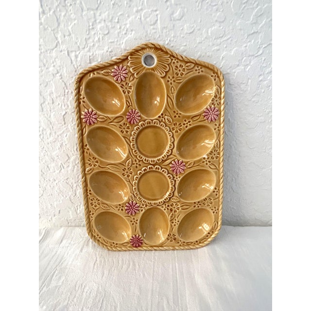 Charming vintage majolica egg plate in gold featuring embossed tone on tone flowers with pink floral accents. Hole on top...