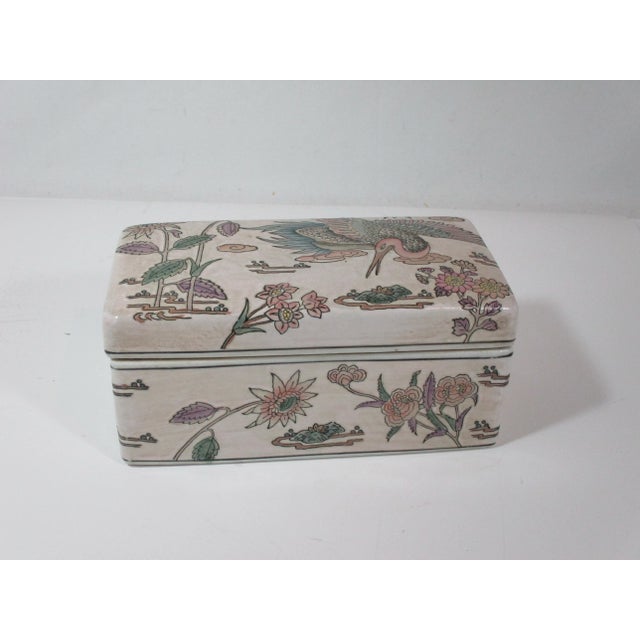 This is a vintage Chinese porcelain rectangular keepsake box . It is hand painted and decorated with a large phoenix bird...