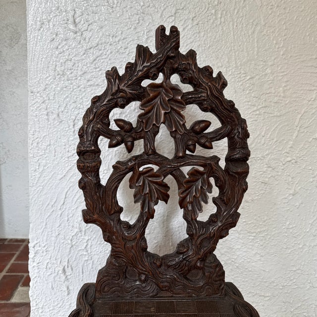A 19th century Black Forest Bavarian hall chair with intricately carved naturalistic features of branches for the legs and...