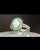 A vintage 14K white gold cocktail ring featuring a green opal cabochon at its center, encircled by a vivid halo of chrome...