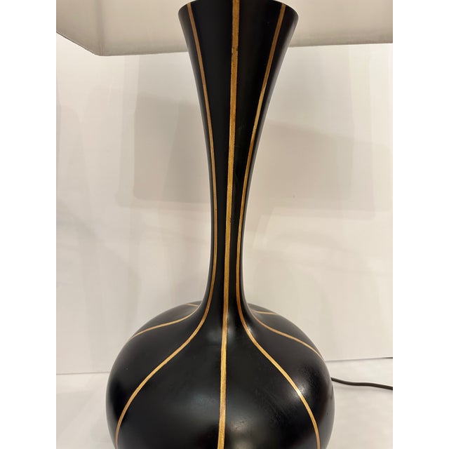Stylish pair of sculptural black and gold striped mid century modern table lamps having sensual shape on steel bases....