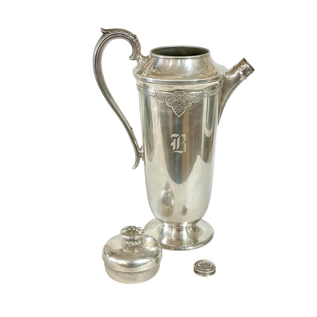 Antique 1920’s silver plate cocktail shaker by Rogers & Son. Features a two part screw in lid and cork lined spout cover....