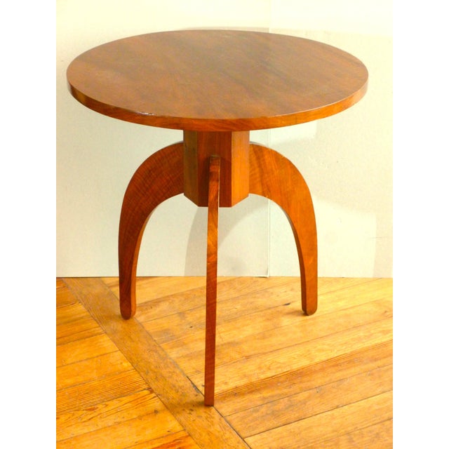 A tripod side table in walnut and walnut veneer, dating from the 1930s/40s, with a circular top surmounting a hexagonal...