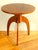 A tripod side table in walnut and walnut veneer, dating from the 1930s/40s, with a circular top surmounting a hexagonal...