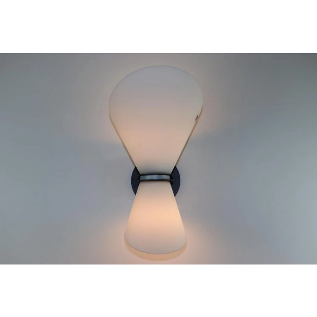 Murano wall lamp with blown glass, and white satin finish and white interior. Mounting in embossed black lacquered metal...