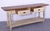 This antique wooden console table features a charming distressed finish that highlights its aged character. Crafted from...