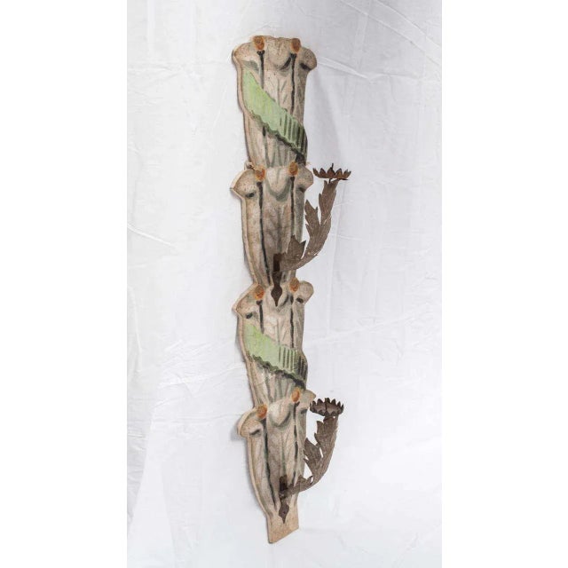 This 18th century wall-mounted candle holder is covered in painted paper.