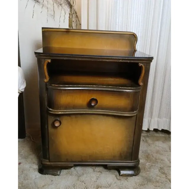 Pair of art deco nightstands, is constructed of wood in a walnut finish and was made in Czechslovakia in the 1930s. They...