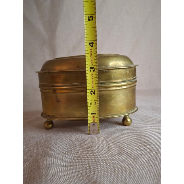 This elegant oval brass box is a charming relic of 19th-century craftsmanship. Historically utilized as a personal tobacco...