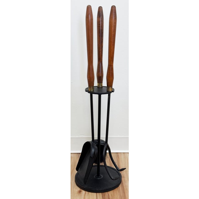 Vintage Mid-Century Modern three piece fireplace tool set with stand. Sturdy teak wood handles top iron tools including...