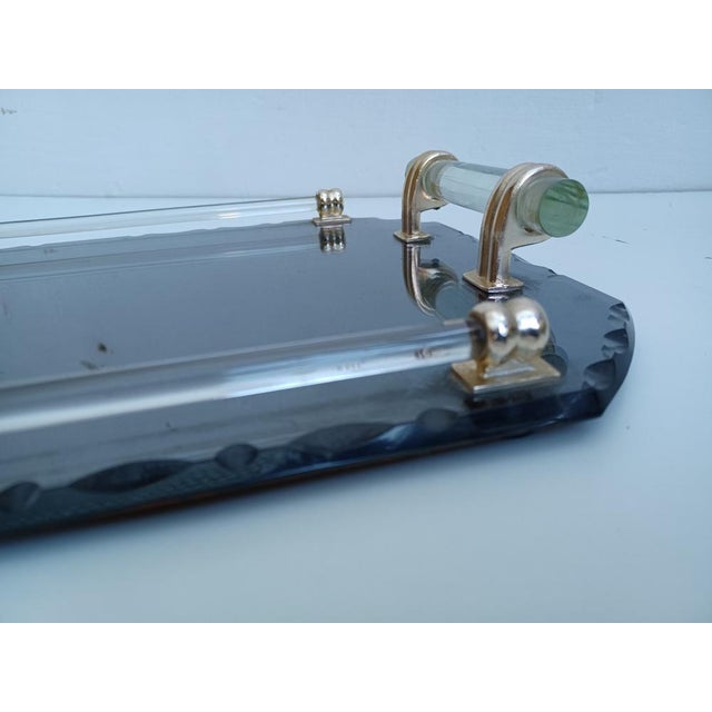 Smoked and beveled mirror tray, handles and glass rim, fixed by a golden metal structure.