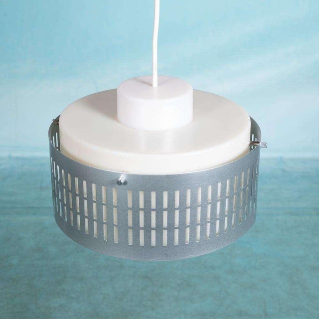 Minimalist hanging lamp from the 1970s made of matte semi-transparent acrylic and openwork aluminum. The semi-transparent...