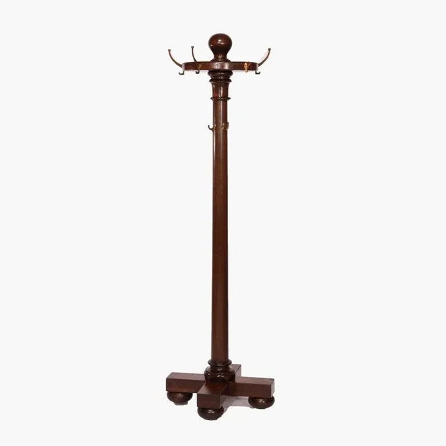 An antique Arts and Crafts hall hat rack offers mahogany construction with turned column seated on base with bun feet,...