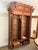A monumental Victorian knockdown bookcase featuring two large glass doors, intricate wood carvings, engaged columns, and a...