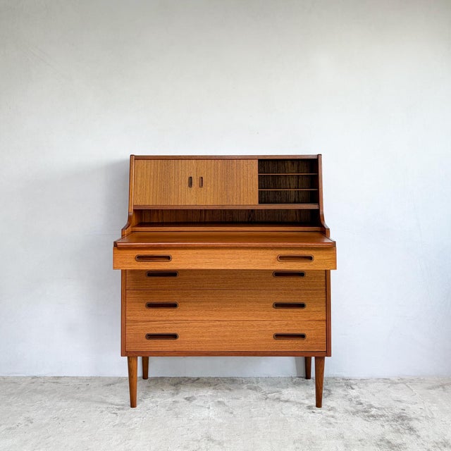 A teak bureau that works as a desk, a dressing table and a chest of drawers. The top section pulls out as one piece. Its...