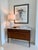 The Waterson lamp features a substantial white marble column base accented with antique brass detailing, creating a...