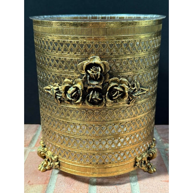 Fabulous vintage Hollywood Regency style wastebasket featuring gold filigree ormolu with a prominent rose design on the...