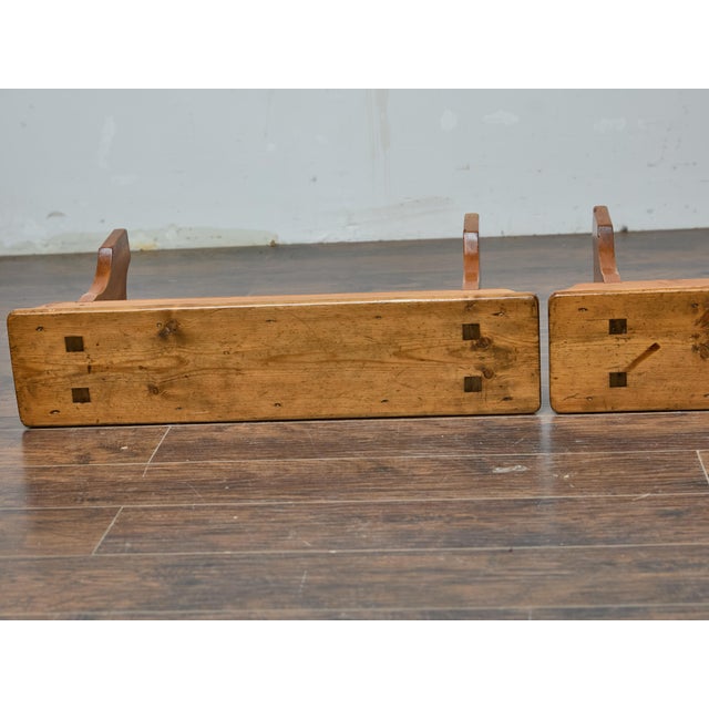 Crafted from solid pine with a warm, timeworn patina, this pair of American benches from circa 1920 embodies rustic charm...