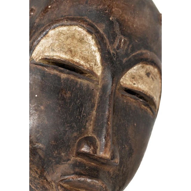The Baule portrait mask discussed is intricately crafted for the Mblo dance, representing an honored person or ancestor in...