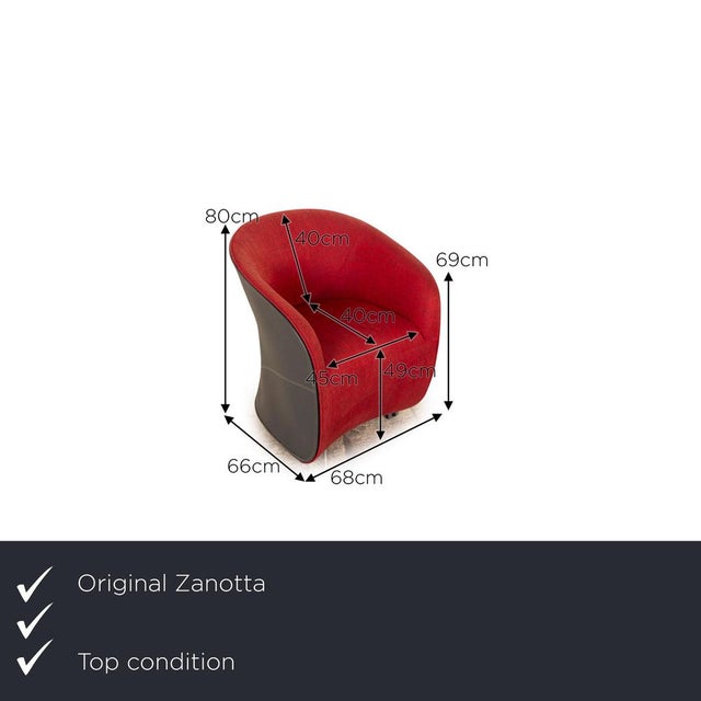 The Calla armchair from Zanotta is covered in red fabric and stands on black wheels. The rounded armrests and the simple...