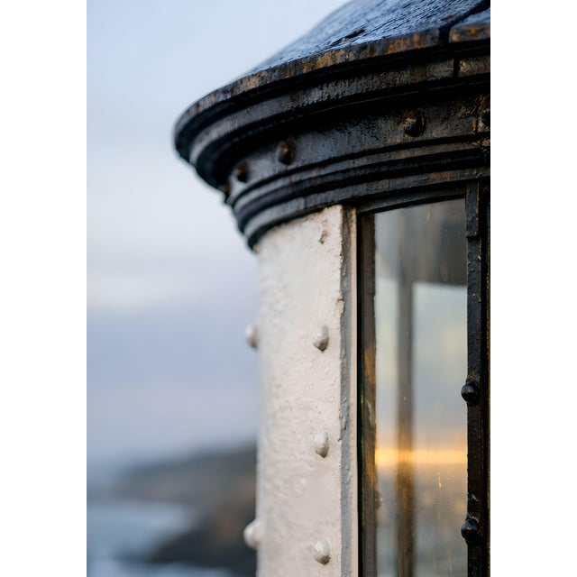 Vintage-inspired coastal artwork featuring a close-up of a glowing lighthouse Fresnel lens, rendered with rich detail and...