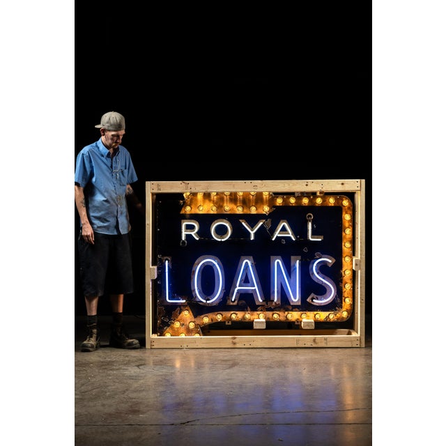 A large double-element neon sign advertising Royal Loans, built with both neon tubing and a surrounding field of...