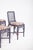 Six plaited wicker chairs. Painted in a dark colour with a padded seat. The high backrest, with its straight lines, has an...