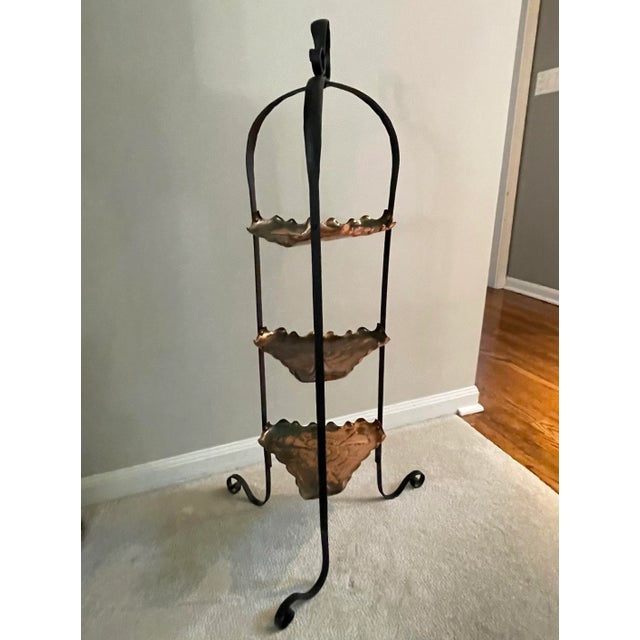 Unique and quirky vintage three tier stand made of black iron and copper. The three triangular copper tiers/shelves have...