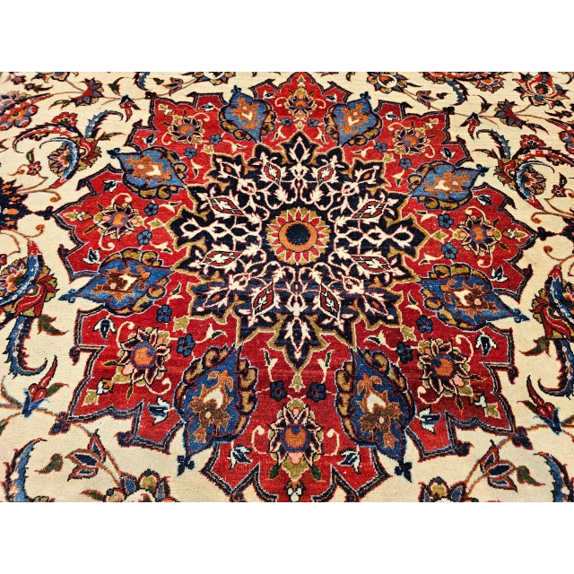 An elegant and finely woven vintage Persian Isfahan room size rug, hand-knotted in the mid-20th century and showcasing the...