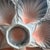 A beautifully sculptural French oyster plate, featuring six shell-shaped wells in soft, luminous gradients of blush pink...