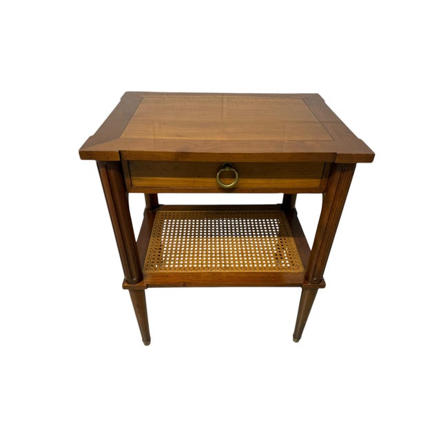 Elegant mid-century end table by Baker Furniture. This classic piece features a single drawer for storage, a woven rattan...