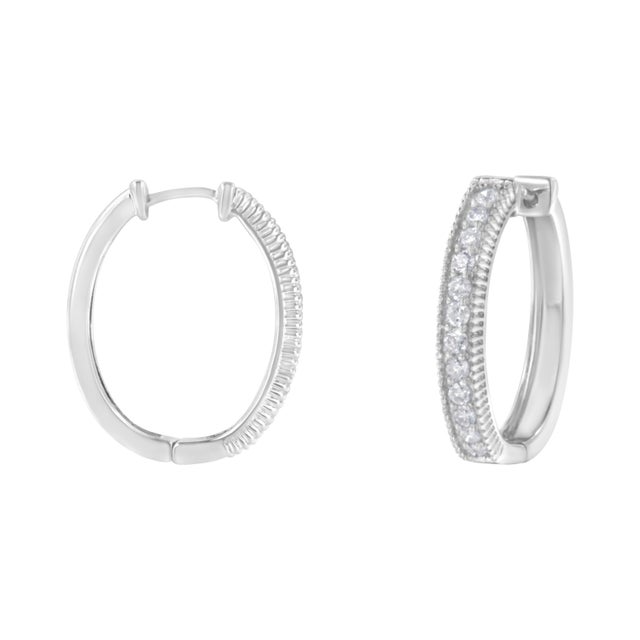 A pair of modern diamond hoop earrings that feature a row of round diamonds. Crafted in 10 karat white gold, they have a...