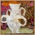 A chunky white vase with four looped handles stands against a backdrop of orange, magenta and paisley-patterned fabric,...