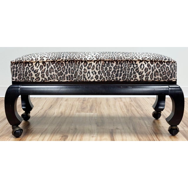 Vintage ebonized carved wood Ming style bench or footstool on casters. Newly upholstered animal print is piped at edges...
