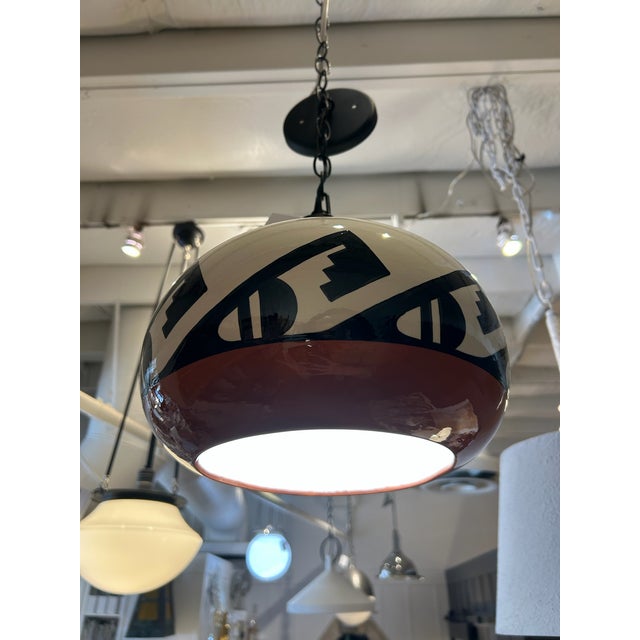 Vintage ceramic pendant light featuring a bold Southwest-inspired geometric design. The rounded globe form showcases...