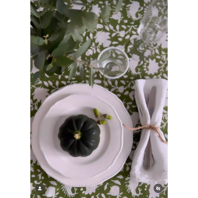 Hand block printed table runner featuring a classic floral design in olive green and green rich cotton tassels on each...