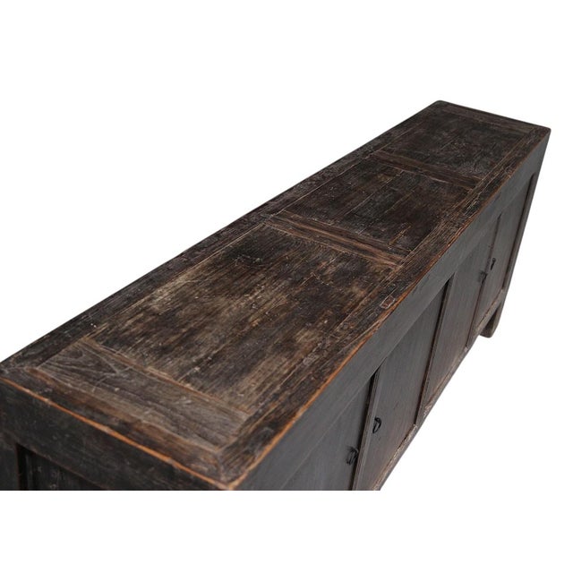 This vintage sideboard is made from reclaimed solid wood featuring a heavily weathered, dark charcoal brown finish with...
