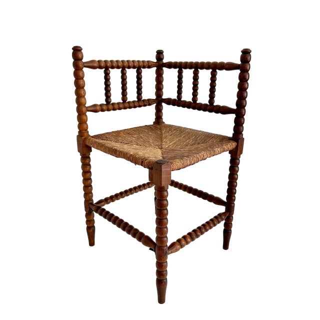 This early 1900s Dutch oak bobbin corner chair with rush seat has time earned patina. Hand-turned spindles are an example...
