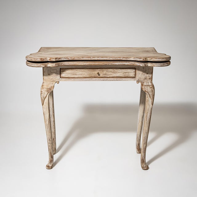Games table on cabriole legs with a drawer set into the straight apron and rounded corners. The folding top opens to...