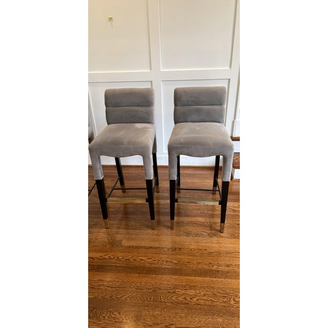 Sophisticated and sculptural, this set of four TOV bar stools features plush smoke-gray velvet upholstery, elegantly...