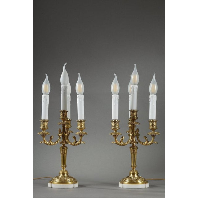 A pair of louis xvi style gilt bronze candelabra, made in the early 20th century. They embody the understated elegance and...
