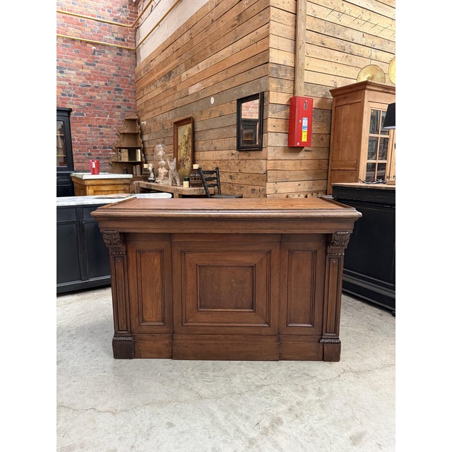 This antique solid oak counter has been fully restored. Its front is adorned with geometric moldings. On the back, it...