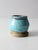 This vintage studio pottery mug features a bold, bulbous shape with a speckled turquoise drip glaze layered over a warm...
