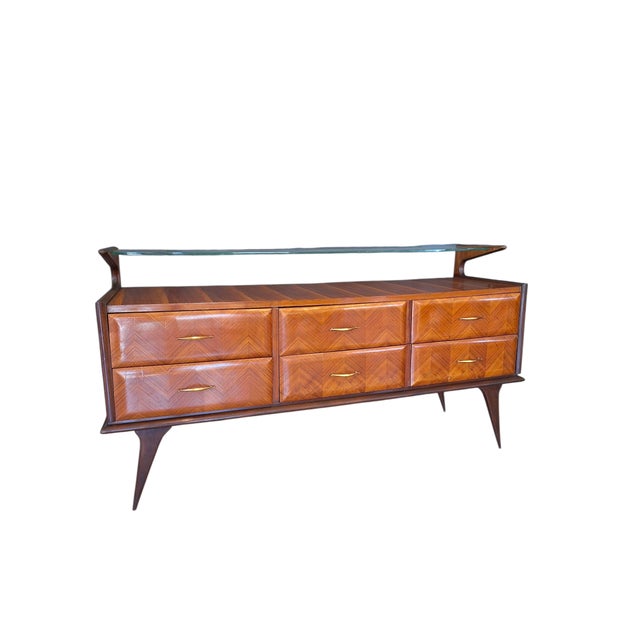 Large 4-drawer chest of drawers with raised glass shelf and brass handles. The piece of furniture was made in Italy in the...