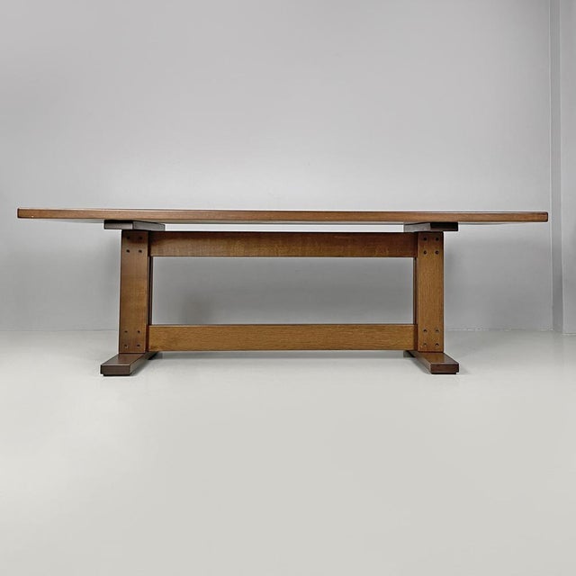Italian modern rectangular wooden dining room table with two central beams 1970s Dining table in wood. It has two legs...
