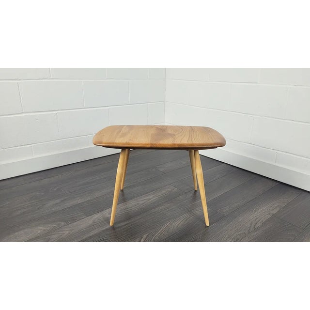 - Solid English elm round coffee or side table with beech legs - Produced by Ercol during the 1960s - Refinished in our...