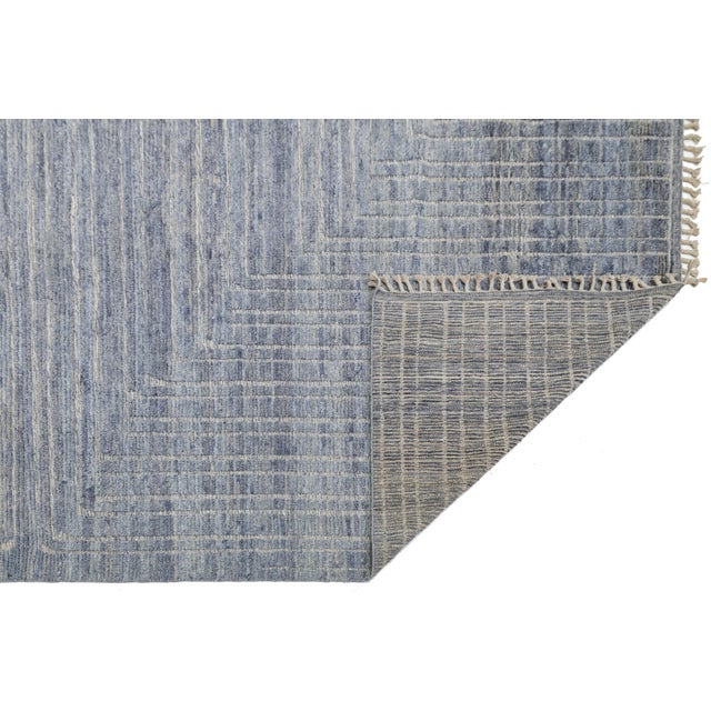 Elevate your space with this stunning modern Moroccan-style rug, featuring a sophisticated slate blue palette and a...